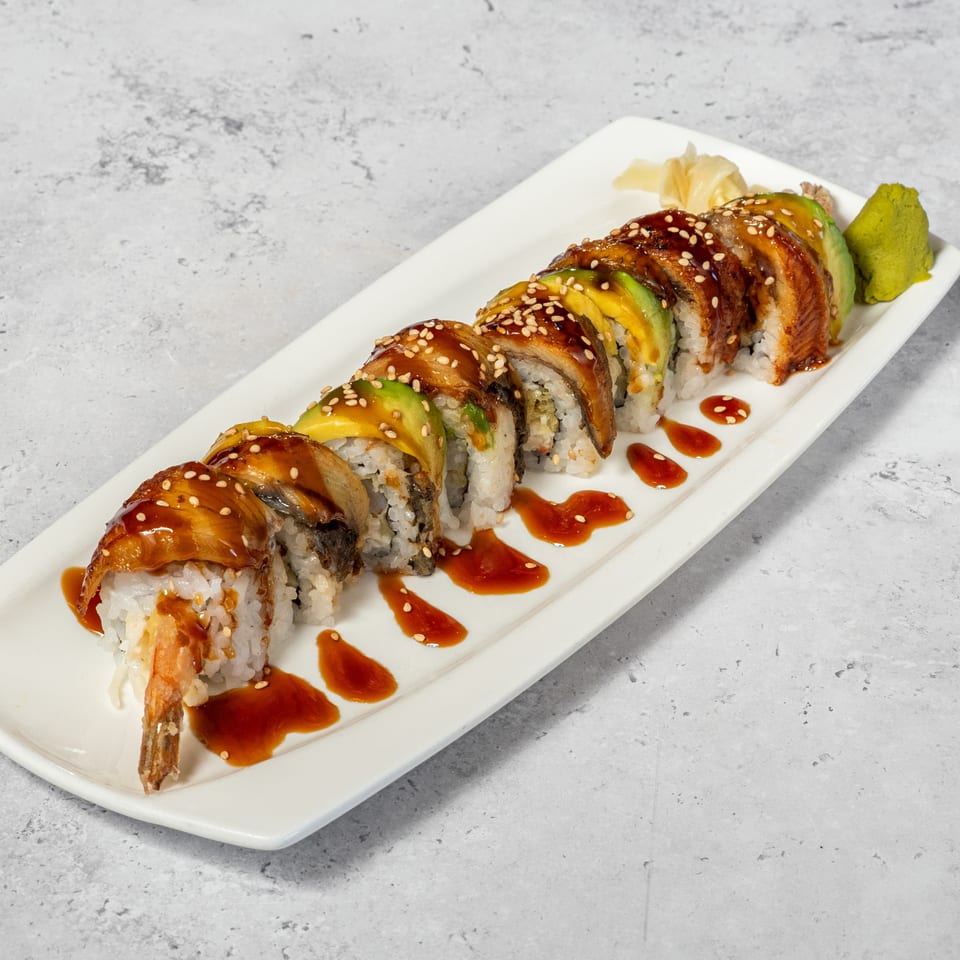 Dragon Roll topped with eel and avocado, served with ginger and wasabi.